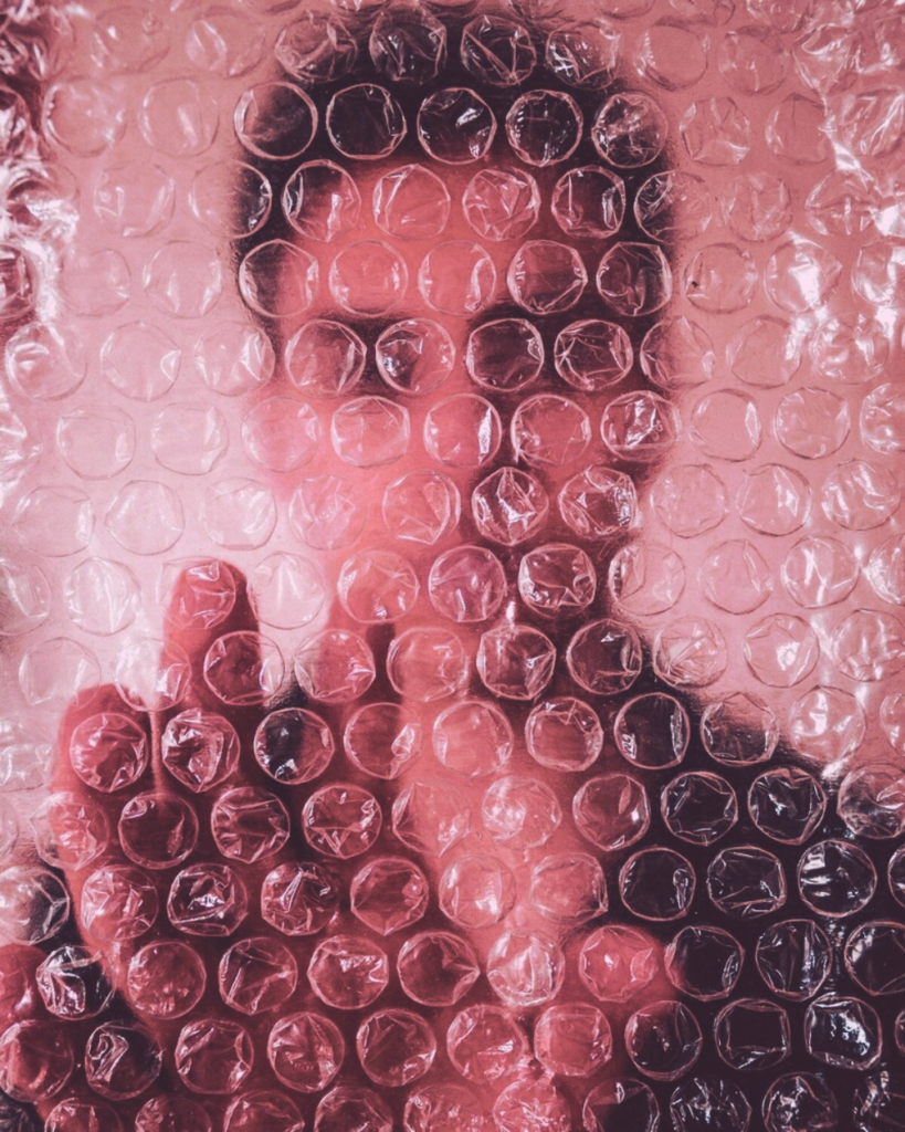 a person's face behind bubble wrap